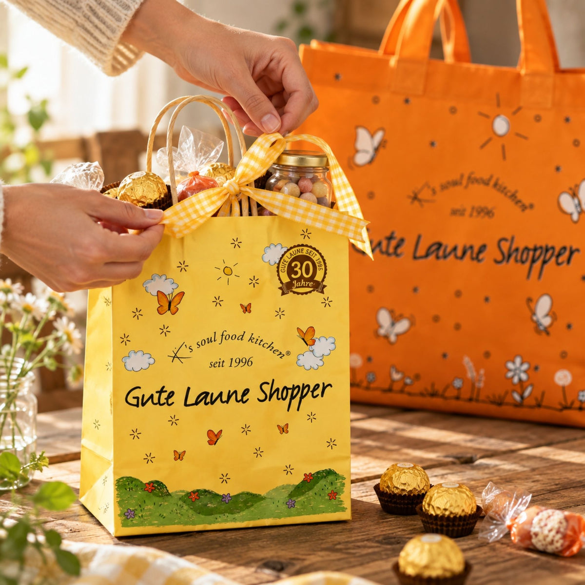 Kleine gelbe Geschenktasche aus Papier mit Süßigkeiten als Mitbringsel