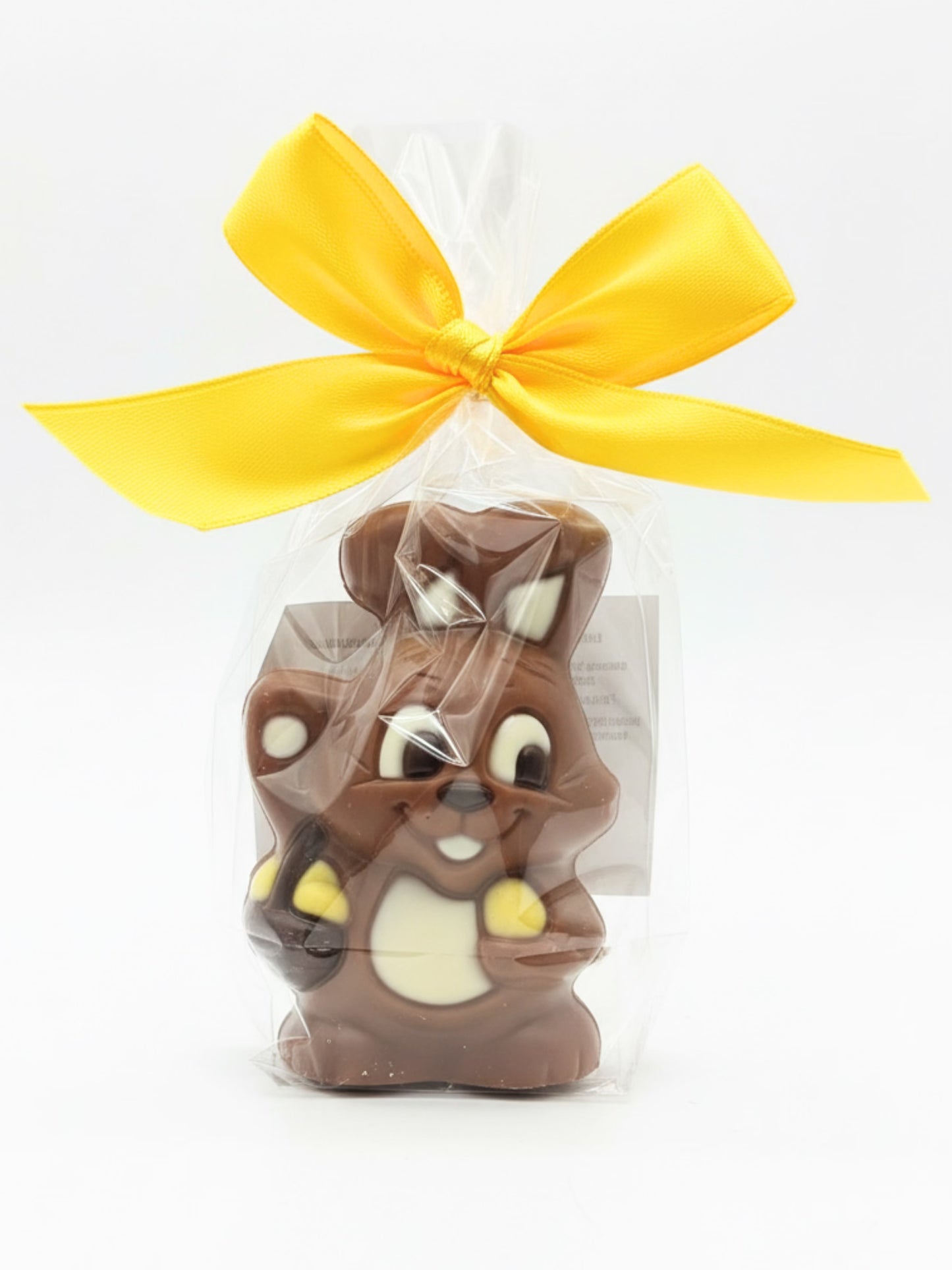 Schokoladen-Hase „Noèmi“ 40g von Sweet-Konzept, niedliche Schokofigur aus Edelvollmilch-Schokolade in Folie mit gelber Schleife, erhältlich in der Dreyer Confiserie in der Rattenfängerstadt Hameln.